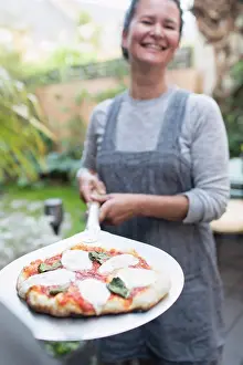Basil Prints: Portrait happy woman cooking fresh homemade pizza outdoors