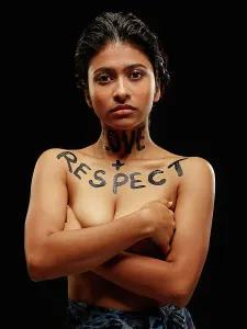 Activism Prints: Portrait of Indian woman with arms crossed and words painted across neck and chest Love + Respect