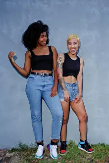 Denim Prints: Portrait of two joyful beautiful young women standing together
