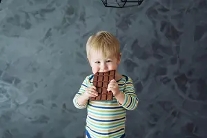 Nahaufnahme Prints: Portrait of an littel boy eating chocolate Portrait of an adorable baby eating chocolate