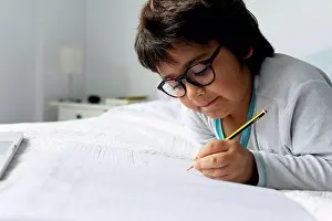 Upper Body Prints: Portrait of little boy lying on bed doing homework