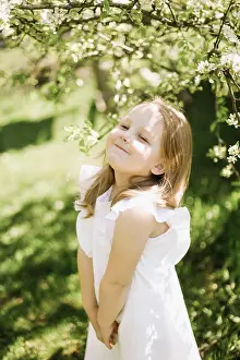 Hinreissend Prints: Portrait of little toddler girl in white romantic dress in blossoming garden in spring