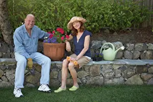 Bald Prints: Portrait of a mature couple sitting in a garden and smiling