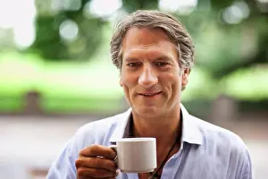 50 To 55 Years Prints: Portrait of a mature man outdoors drinking a cup of coffee