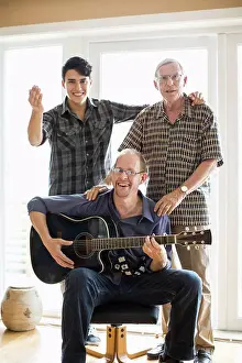 Entrances Prints: Portrait of mature man playing guitar for father and son at home