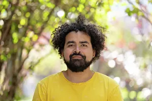 Curly Prints: portrait of a Mexican man with afro isolated on bokeh background