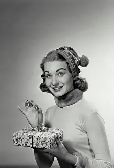Opening Prints: Portrait of a mid adult woman holding a Christmas present