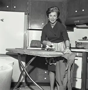 Wristwatch Prints: Portrait of a mid adult woman ironing clothes