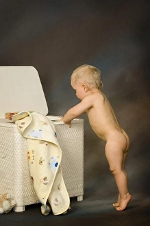 Studio Shots Prints: Portrait of a naked toddler playing in the hamper