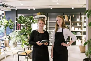 Communications Prints: Portrait of owner holding digital tablet while standing with confident partner at store
