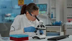 Analysis Prints: Portrait of scientist looking through microscopic lens in laboratory