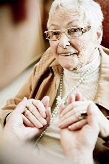 50 60 Years Prints: Portrait of senior woman with Alzheimer's disease holding hands of her adult daughter
