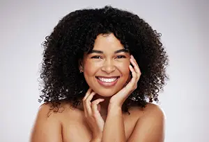 Portrait, skincare and afro with a model black woman in studio on a gray background for natural hair treatment
