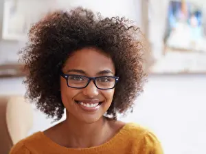 Curly Prints: Portrait, smile and relax woman in home lounge