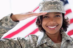 Gleeful Prints: Portrait of smiling Mixed Race soldier saluting near American flag