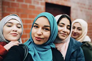Stockholm Prints: Portrait of smiling Muslim friends against building in city