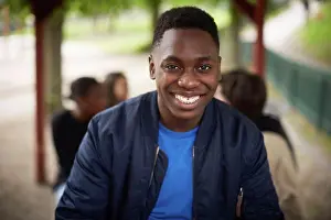 Chic Prints: Portrait of smiling teenage boy sitting at park