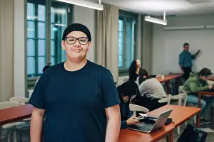 Instruction Prints: Portrait of teenage boy with classmates at desk in classroom