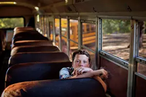 Students Prints: Portrait of a teenage boy sitting in an empty bus
