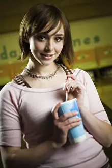 Disposable Prints: Portrait of a teenage girl holding a disposable glass of cola and smiling