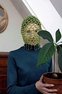 Uniqueness Prints: Portrait of teenage girl wearing crocheted green headdress holding potted avocado plant
