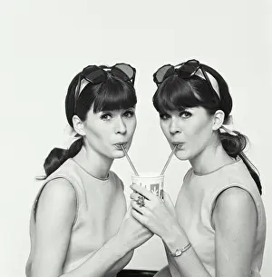 Refreshment Prints: Portrait of twin young women drinking cold drink