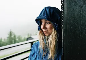 Raindrop Prints: portrait of a woman stood in a doorway in a raincoat in Norway
