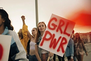 Activist Prints: Portrait of women protesting with friends for human rights in city against sky