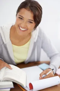 Exam Prints: Portrait, writing and happy student studying in college