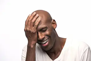 Bald Prints: Portrait of young bald African American man with hand on his head looking down with eyes closed