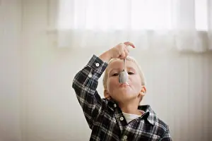 Oneperson Only Prints: Portrait of a young boy with a spoon in his mouth