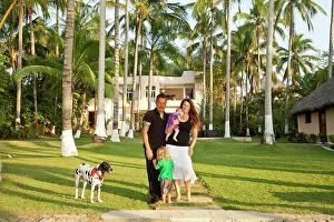Domestic Dogs Prints: Portrait of young family in front of large house