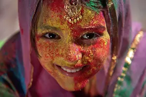 Holi Prints: Portrait of a young girl with duapatta and mangtika on her head smiling on Holi