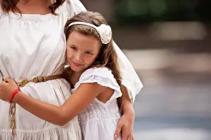 Leafy Prints: Portrait of a young girl standing beside her mother