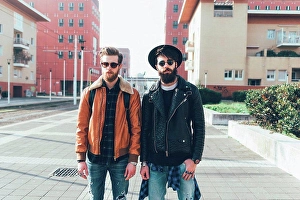 Reality Prints: Portrait of two young male hipster friends standing in city housing estate