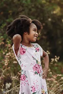 People In Nature Prints: Portrait of young school-aged confident girl posing in field