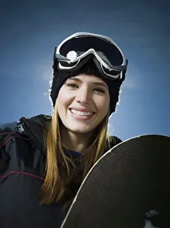 Doors Prints: Portrait of a young woman holding a snowboard