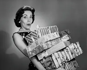 Facial Expression Prints: Portrait of a young woman holding a stack of Christmas present