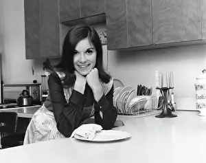 Medium Length Hair Prints: Portrait of a young woman leaning against a kitchen counter