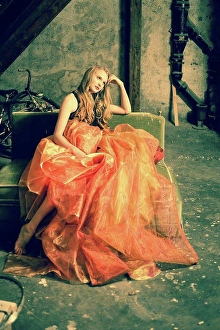 Aspiration Prints: Portrait of young woman sitting at attic wearing orange skirt