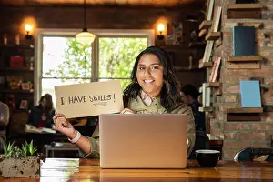 Coworker Prints: Portrait of young woman sitting at table in coffee shop bookstore with laptop computer