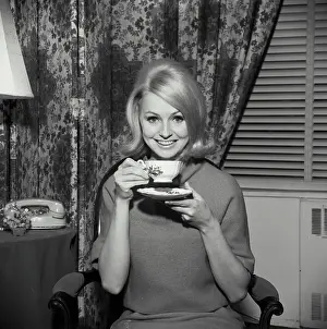 Medium Length Hair Prints: Portrait of a young woman smiling and holding a tea cup