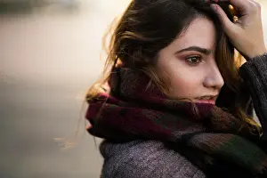 Sweater Prints: Portrait of young woman standing in warm clothes touching her face