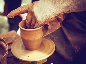 Produce Prints: Potter`s hands shaping up the clay of the pot