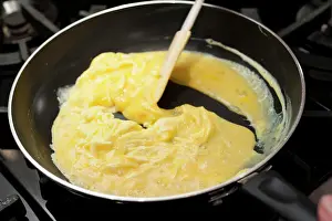 Prepare Prints: Preparing scrambled eggs in a pan