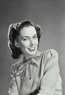 Collar Prints: Pretty brunette woman wearing sweater blouse with tie on collar smiling
