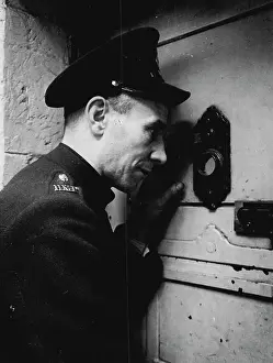 Guard Prints: Prison Officer Davidson operates a peephole to keep tab on the prisoners in their cells