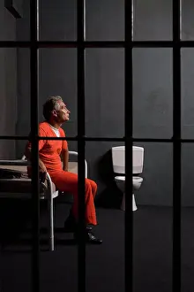 Justice Prints: A prisoner sittin in his prison cell