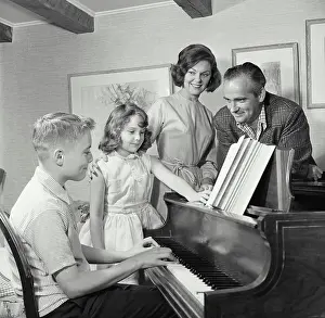 Instrument Prints: Side profile of a boy playing a piano with his family standing beside him