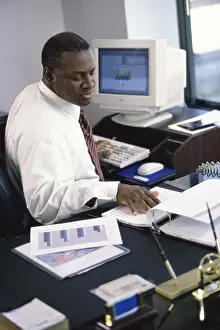 Paperwork Prints: Side profile of a businessman working in an office